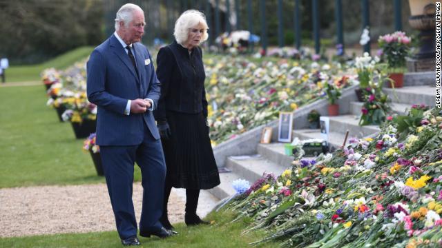 The Duke and Duchess of Cornwall view flower tributes to Philip.