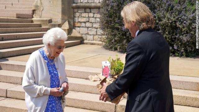 Britain's Queen Elizabeth II reacts as she is presented with a rose, named in memory of her late husband Prince Philip, the Duke of Edinburgh, by President of the Royal Horticultural Society, Keith Weed, at Windsor Castle in Windsor, west of London, on June 2, 2021.