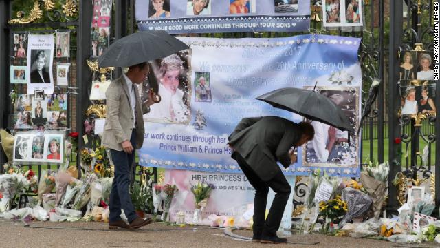 The brothers look upon flowers, photos and other souvenirs left as a tribute to Princess Diana near The Sunken Garden at Kensington Palace on August 30, 2017 in London, England.