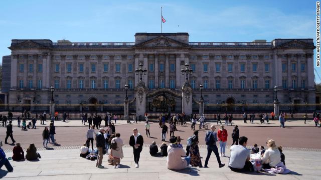 People sit outside Buckingham Palace in central London on April 17.