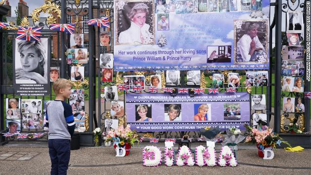 People view tributes left at the gates of Kensington Palace in London on the 24th anniversary of the death of Diana, Princess of Wales. 