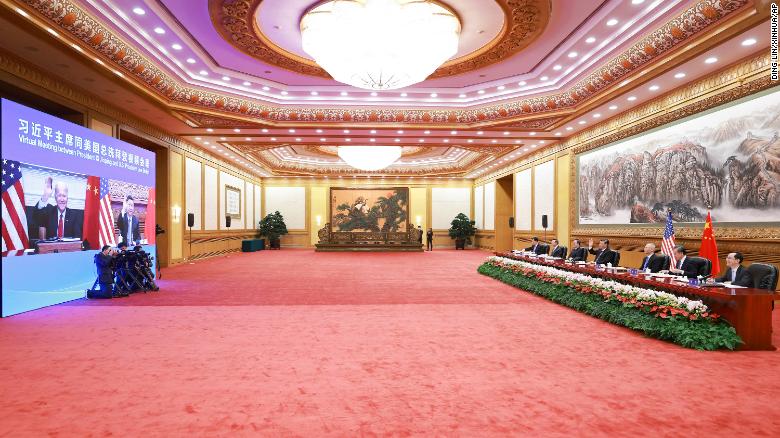 Chinese President Xi Jinping, fourth from right, waves as he greets US President Joe Biden via video link from Beijing on Tuesday in China.