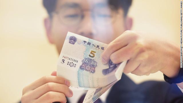 A staff member at China Citic Bank counts 5 yuan banknotes.