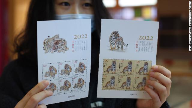 A postal worker shows ''Year of the Tiger'' stamps on January 5 in Nanjing, Jiangsu Province, China.