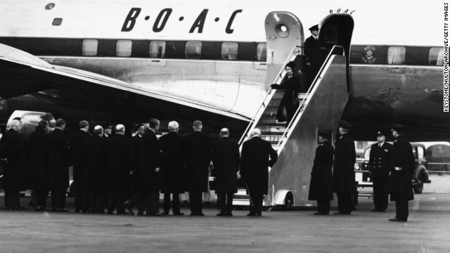 Queen Elizabeth II and Prince Philip deplane on February 7, 1952, after returning from a royal tour in Kenya following the death of King George VI.