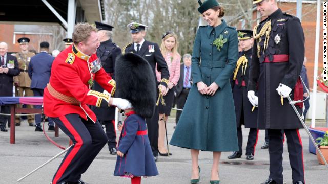 The Cambridges laugh as Lieutenant Colonel Rob Money puts a bearskin hat on his 20-month-old daughter Gaia's head as they attend the 1st Battalion Irish Guards' St. Patrick's Day Parade at Mons Barracks in Aldershot, England on Thursday.