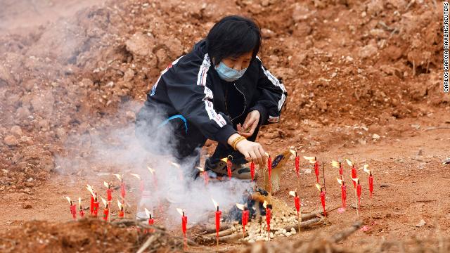 A woman takes part in a Buddhist ceremony in honor of the plane crash victims, in a field near Wuzhou, close to the crash site, on March 22. 