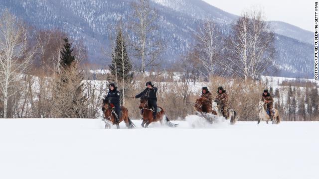 Police officers and border guards patrol on horseback in China's Xinjiang Province on March 24.