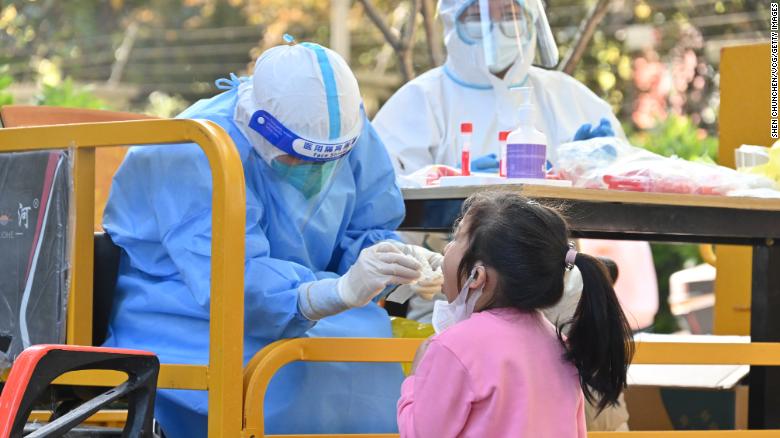 A medical worker takes nucleic acid samples from a child at a gated community after Shanghai imposed a citywide lockdown on April 9.
