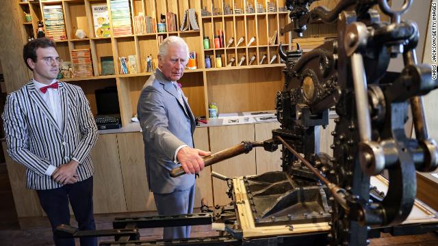 Prince Charles create a lino print on an 1800s printing press during a visit to Hay Castle in Hay-on-Wye.