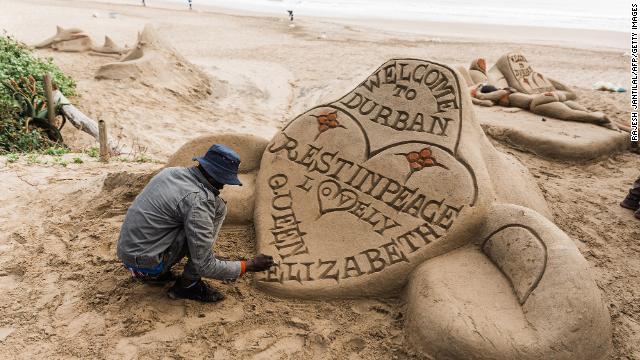 A sand sculptor in Durban, South Africa, puts the final touches on a tribute.