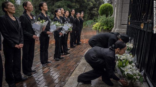 Members of a ballet company lay flowers outside the British Embassy in Tokyo on Friday.