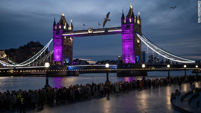 People wait in the queue near the Tower Bridge in London, England, on the last full day of the Queen's lying in state. 