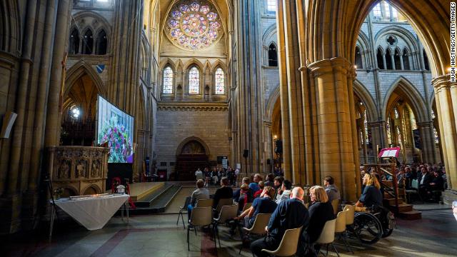 Members of the public watch the funeral at the cathedral in Truro, England.