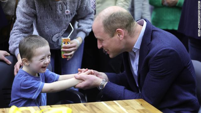 The Prince of Wales holds hands with Tymofii, 4, as he speaks with Ukrainian residents about their experiences of moving to Poland at an accommodation centre in Warsaw on Wednesday evening. 