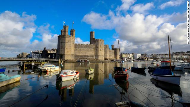 The dramatic Caernarfon Castle is a royal fortress-palace on the banks of the River Seiont in Wales.