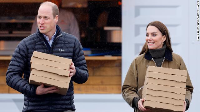 William and Kate carry takeout pizza boxes as they visit Dowlais Rugby Club on April 27 in Merthyr Tydfil, Wales. The Prince and Princess of Wales were visiting the country to celebrate the 60th anniversary of Central Beacons Mountain Rescue.