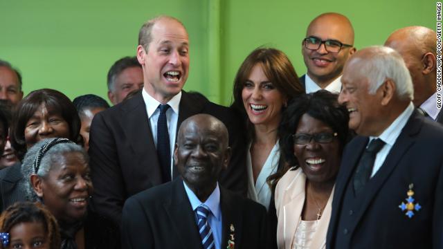 William and Kate laugh with Windrush Elders after the prince made a joke while posing for a picture during a visit to Cardiff, Wales, in celebration with the beginning of Black History Month.