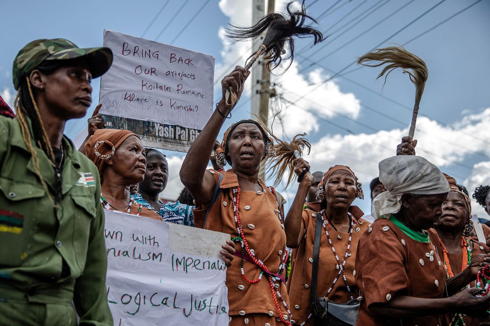 Human rights activists and former freedom fighters hold banners and chant slogans during a small demonstration amid King Charles’ visit.