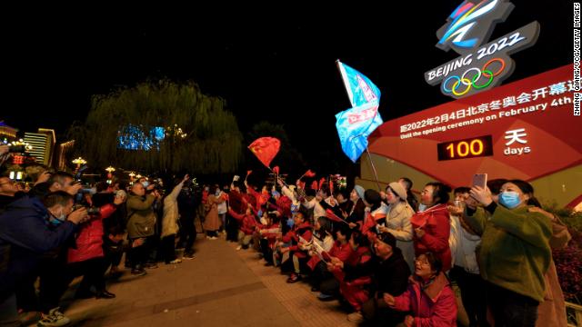 People pose for photos in front of a countdown clock for the Beijing 2022 Winter Olympics on October 26 in Zhangjiakou, Hebei Province of China.