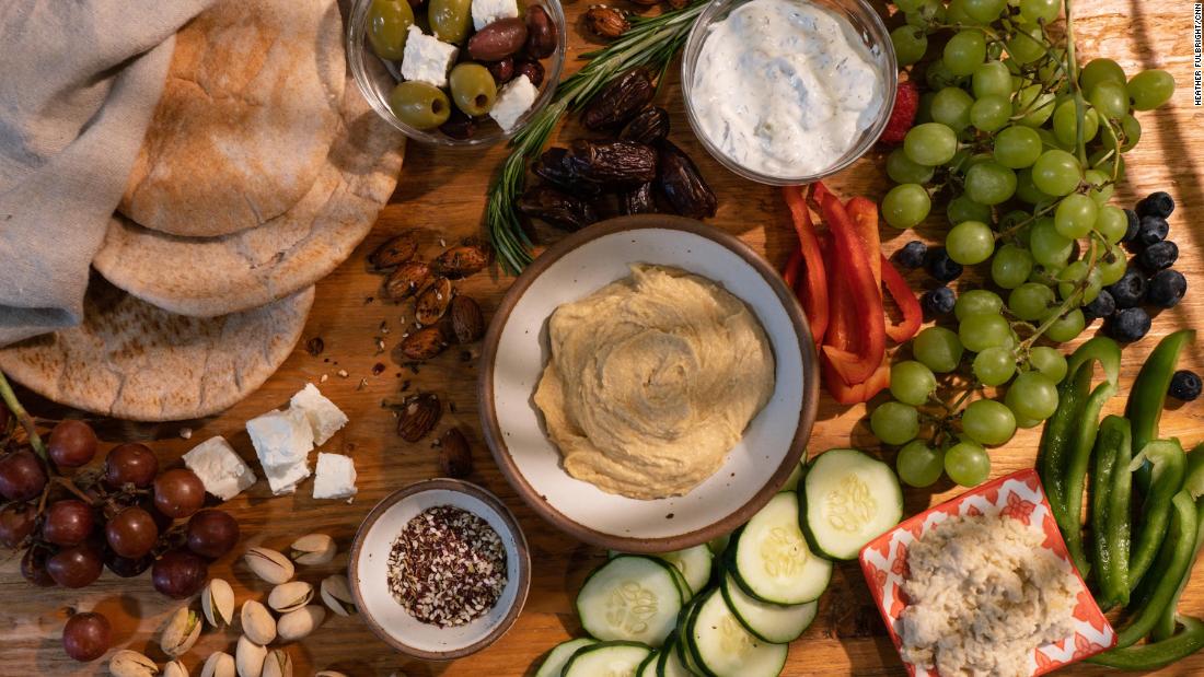 Meze with assorted fruits and vegetables with hummus and dipping sauces