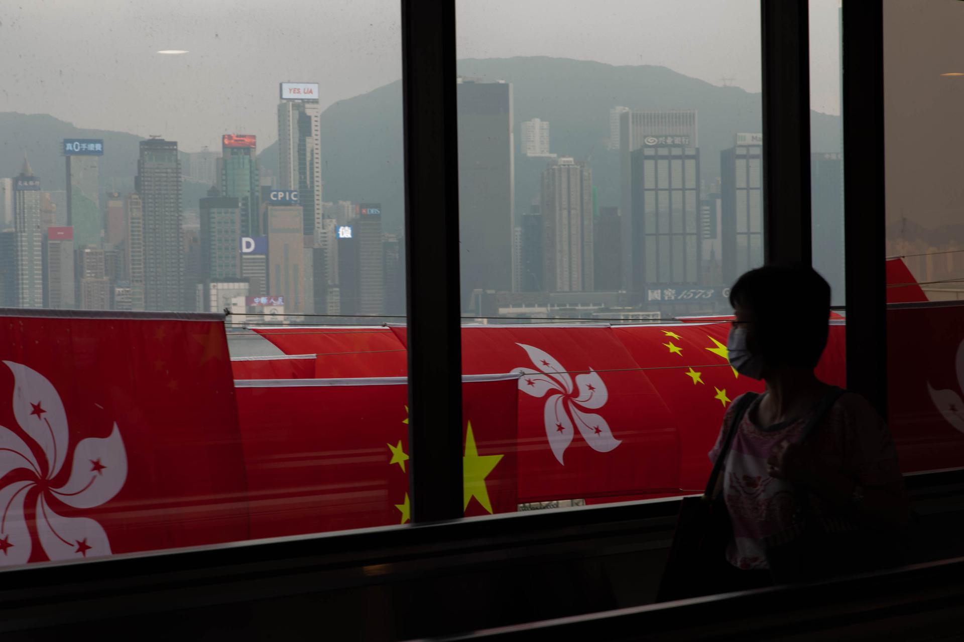 A woman looks out at Hong Kong's Victoria Harbor on September 30, ahead of China's National Day holiday.