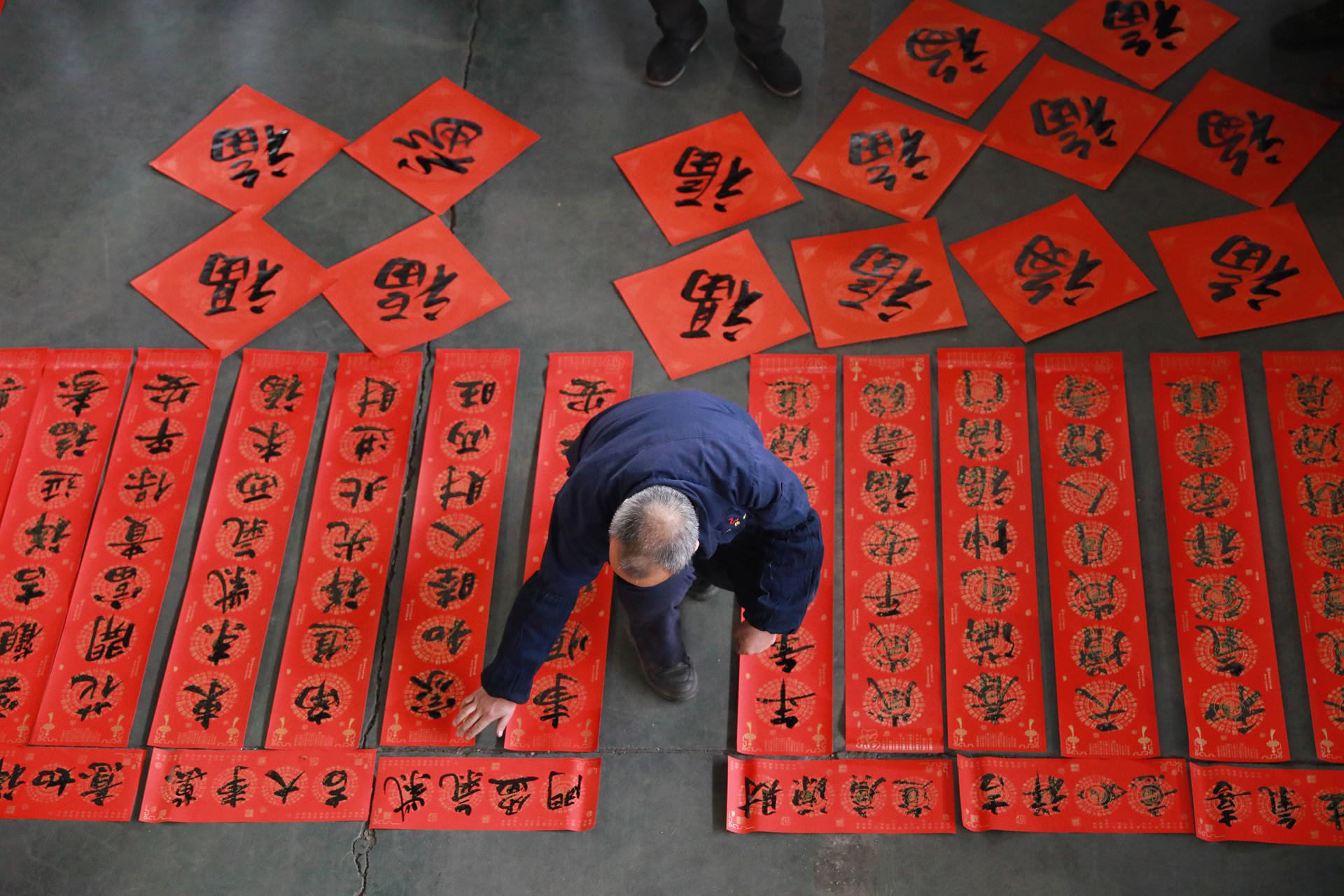 A postal worker shows ''Year of the Tiger'' stamps on January 5 in Nanjing, Jiangsu Province, China.