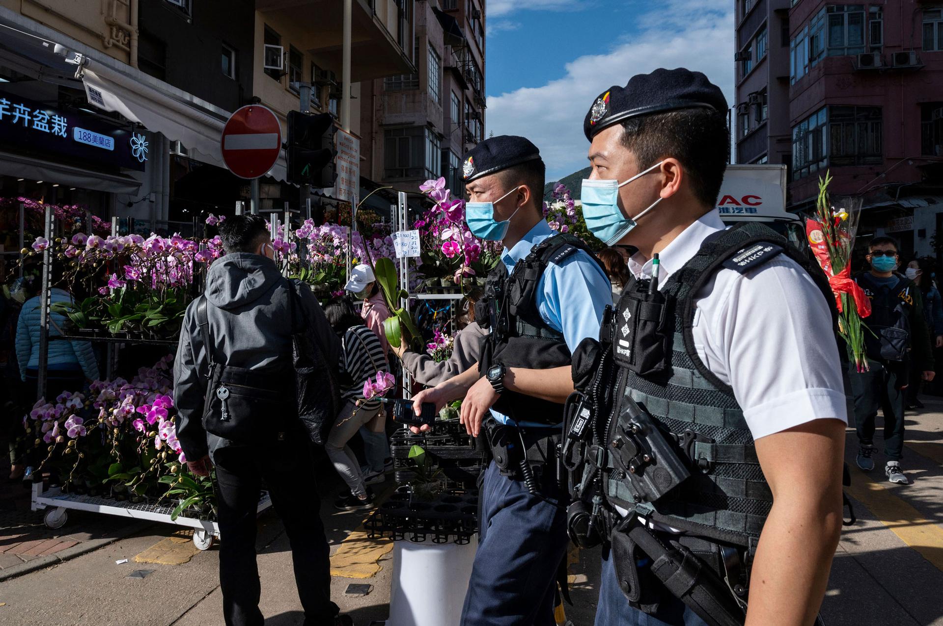 Police patrol a flower market in Hong Kong as people shop ahead of the Lunar New Year festival. 