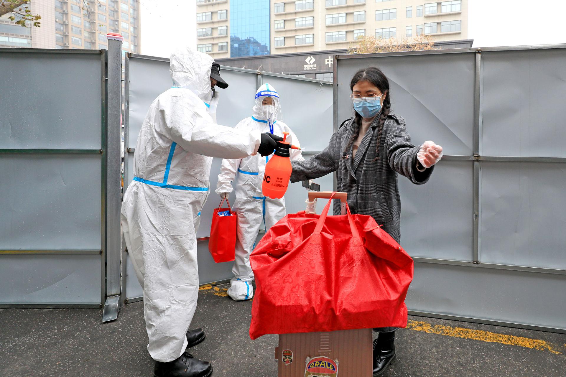 A medical worker sprays disinfectant to a resident outside a lockded-down residential community in Xi'an on January 6.
