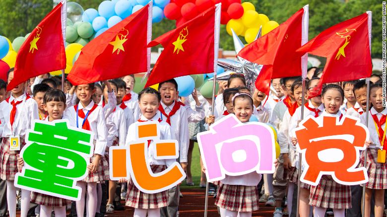 Pupils at a primary school in eastern China's Haian city hold up a slogan pledging loyalty to the Communist Party. 