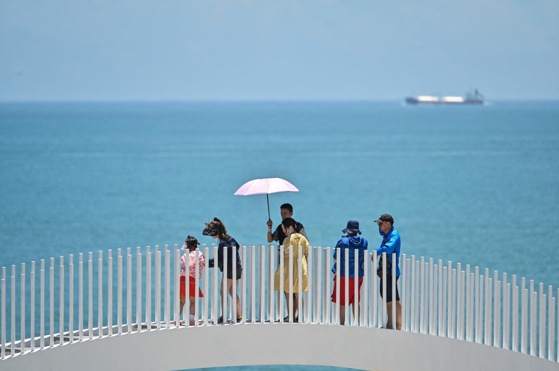 Tourists visit a scenic area on China's Pingtan island during military drills.