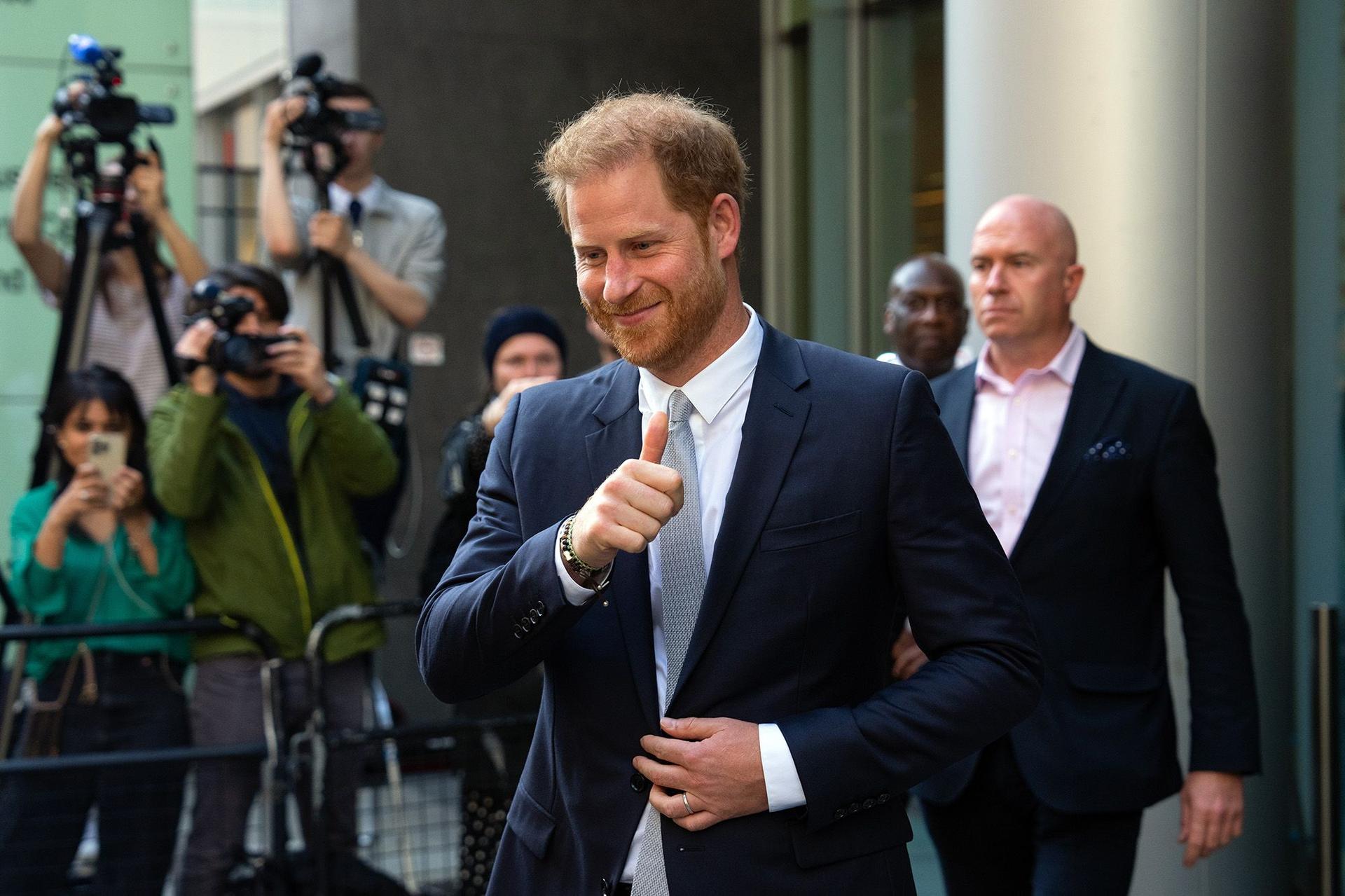 Prince Harry gives a thumbs up to reporters as he leaves the Royal Courts of Justice