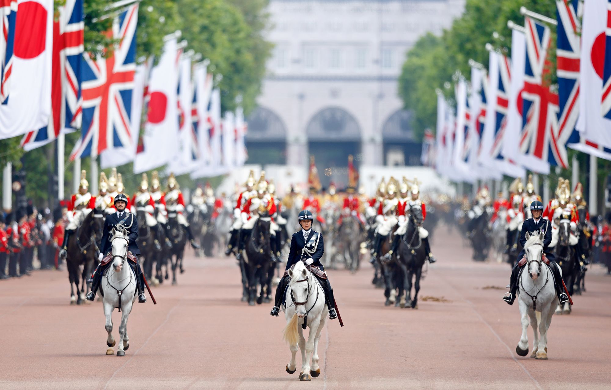 Mounted police officers lead a carriage procession transporting King Charles III, Emperor Naruhito of Japan, Queen Camilla, Empress Masako of Japan and Prince William, Prince of Wales from Horse Guards Parade, down The Mall  which is lined with Japanese and Union flags, to Buckingham Palace on day one of The Emperor and Empress of Japan’s State Visit to the United Kingdom on June 25, 2024. 