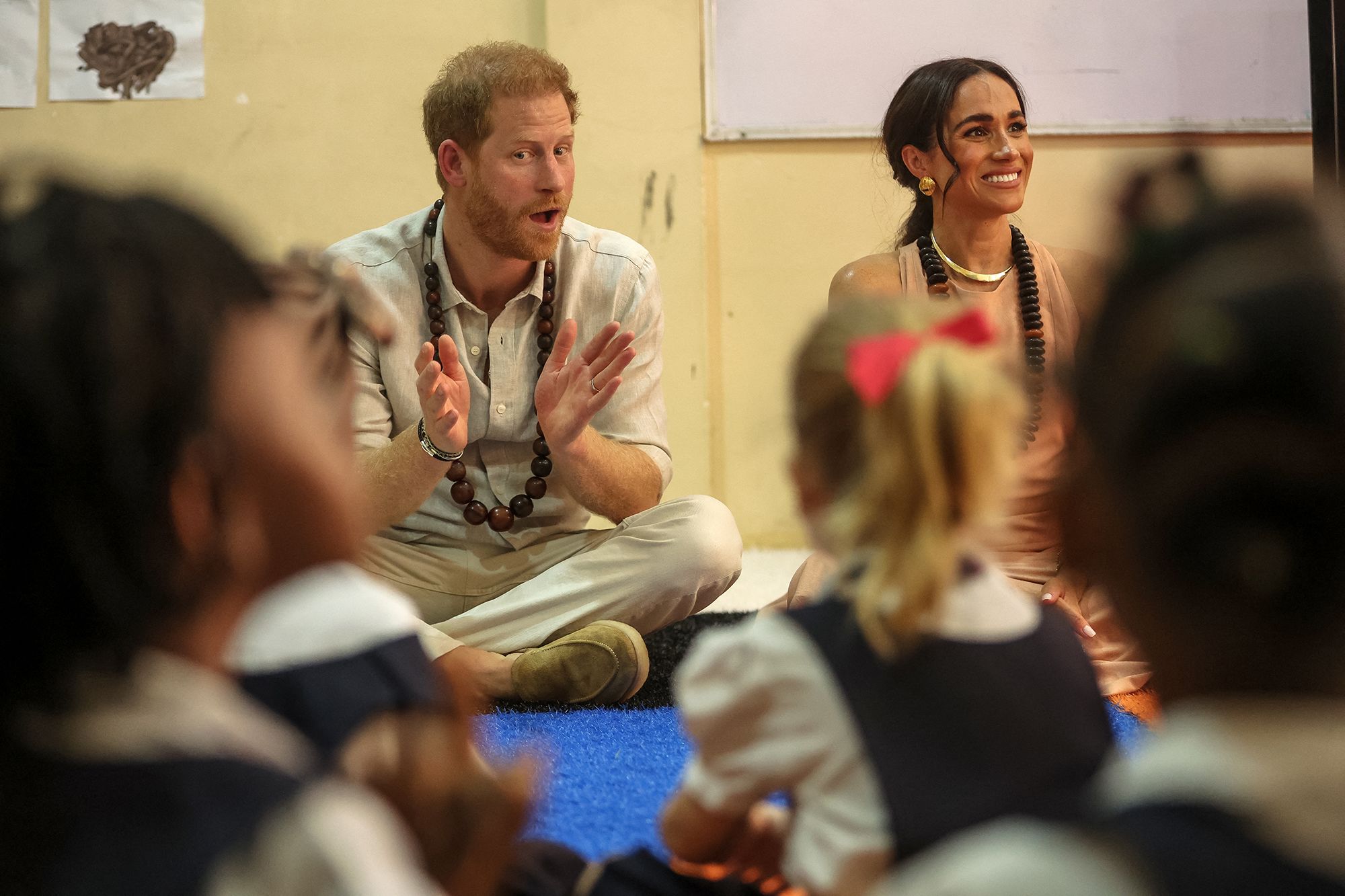 Prince Harry, Duke of Sussex, and Meghan, Duchess of Sussex, sitting on the floor