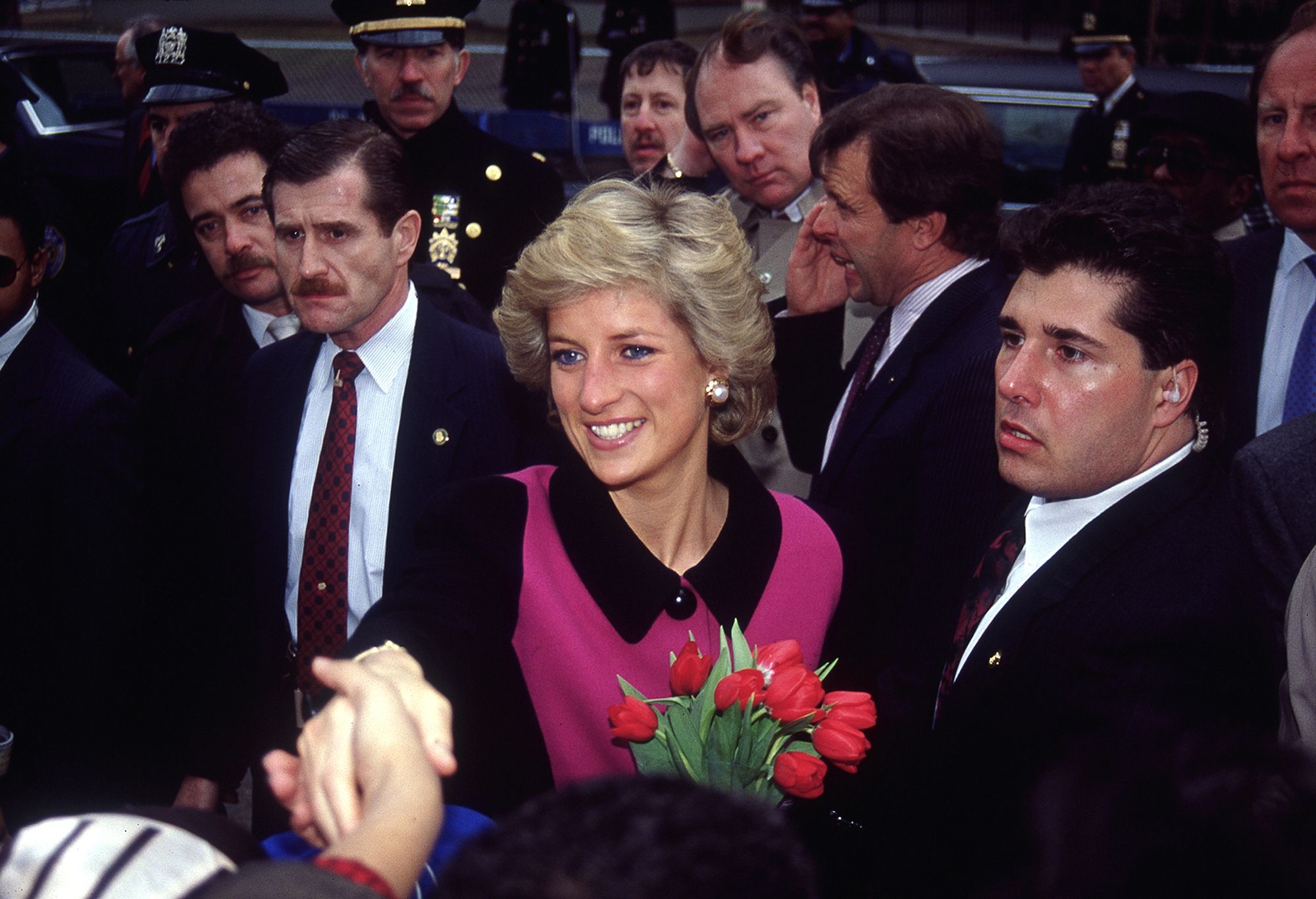 Princess Diana smiling and holding flowers