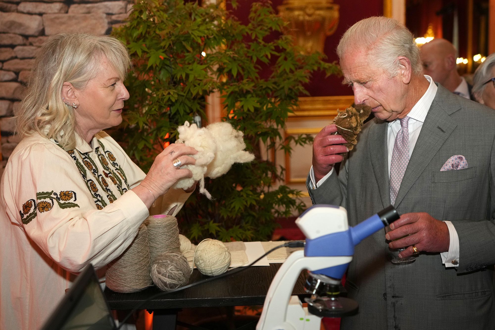 Photo of King Charles smelling a wool sample