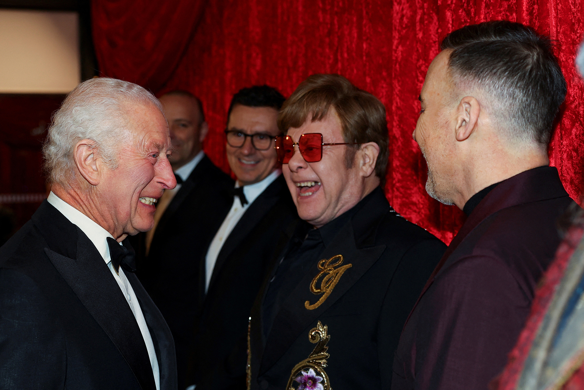 King Charles III laughing with Sir Elton John and David Furnish as he arrives for the Royal Variety Performance at the Royal Albert Hall on November 22, 2024 in London, England.