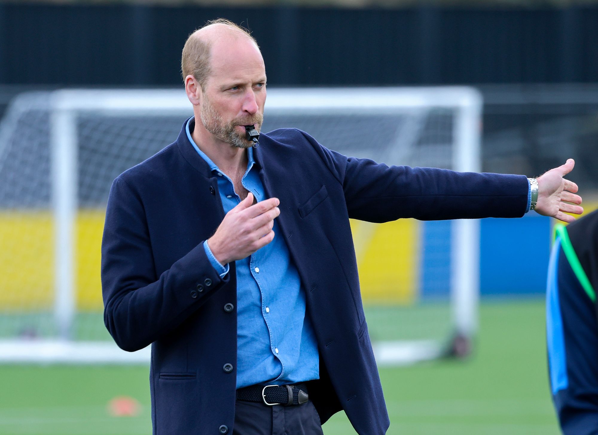 Photo of Prince William blowing a referee's whistle during a football game