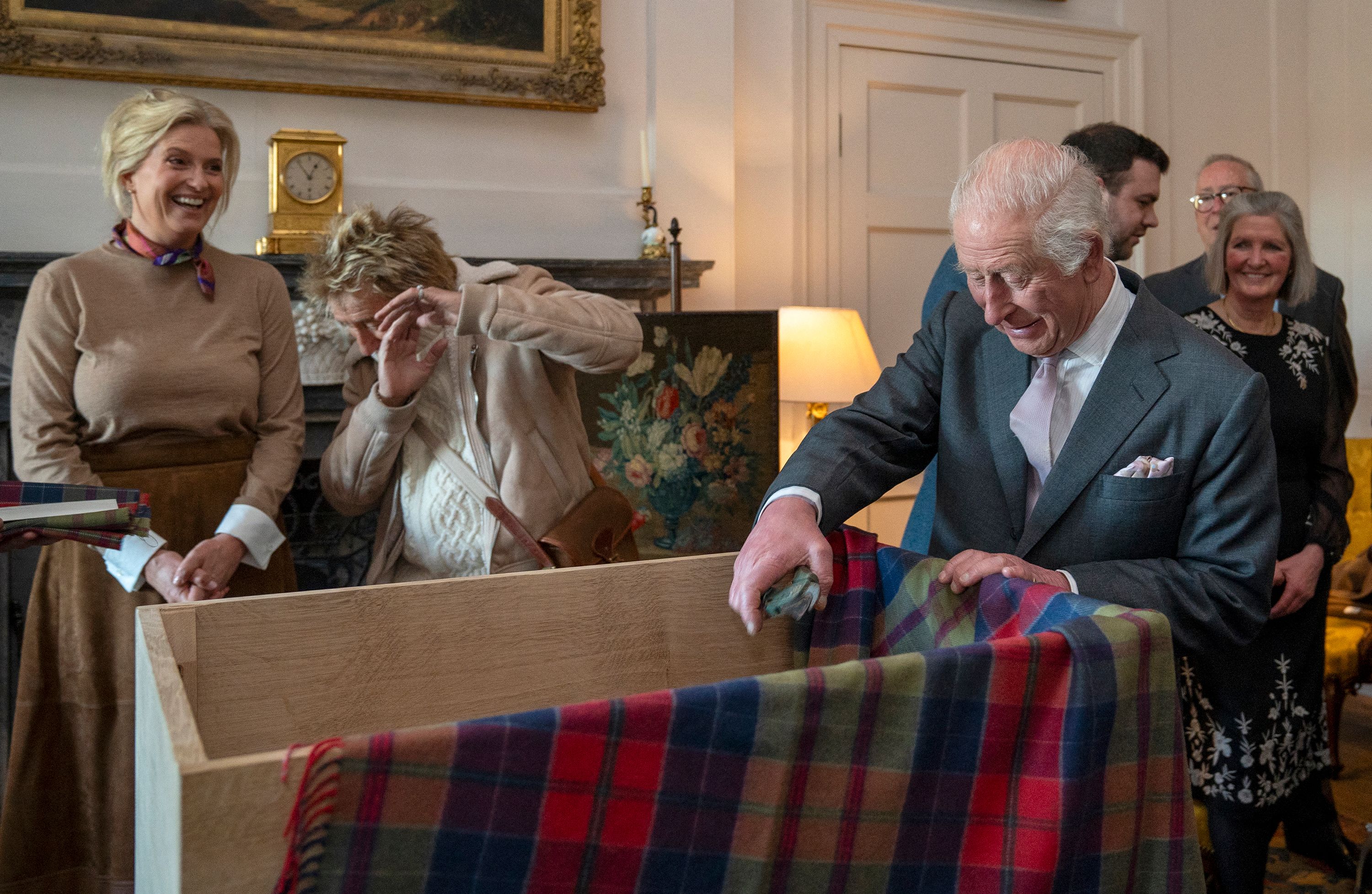 King Charles laughs as he pulls a pair of garden secateurs out of a box