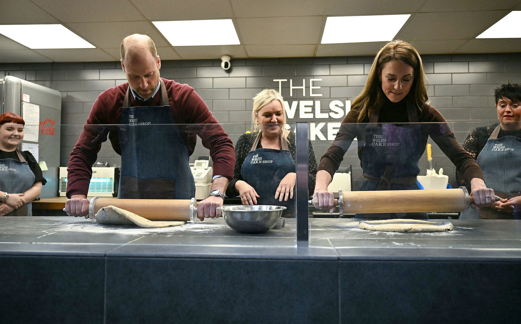 Prince William and Catherine, Princess of Wales use rolling pins while making Welsh Cakes during a visit to Wales