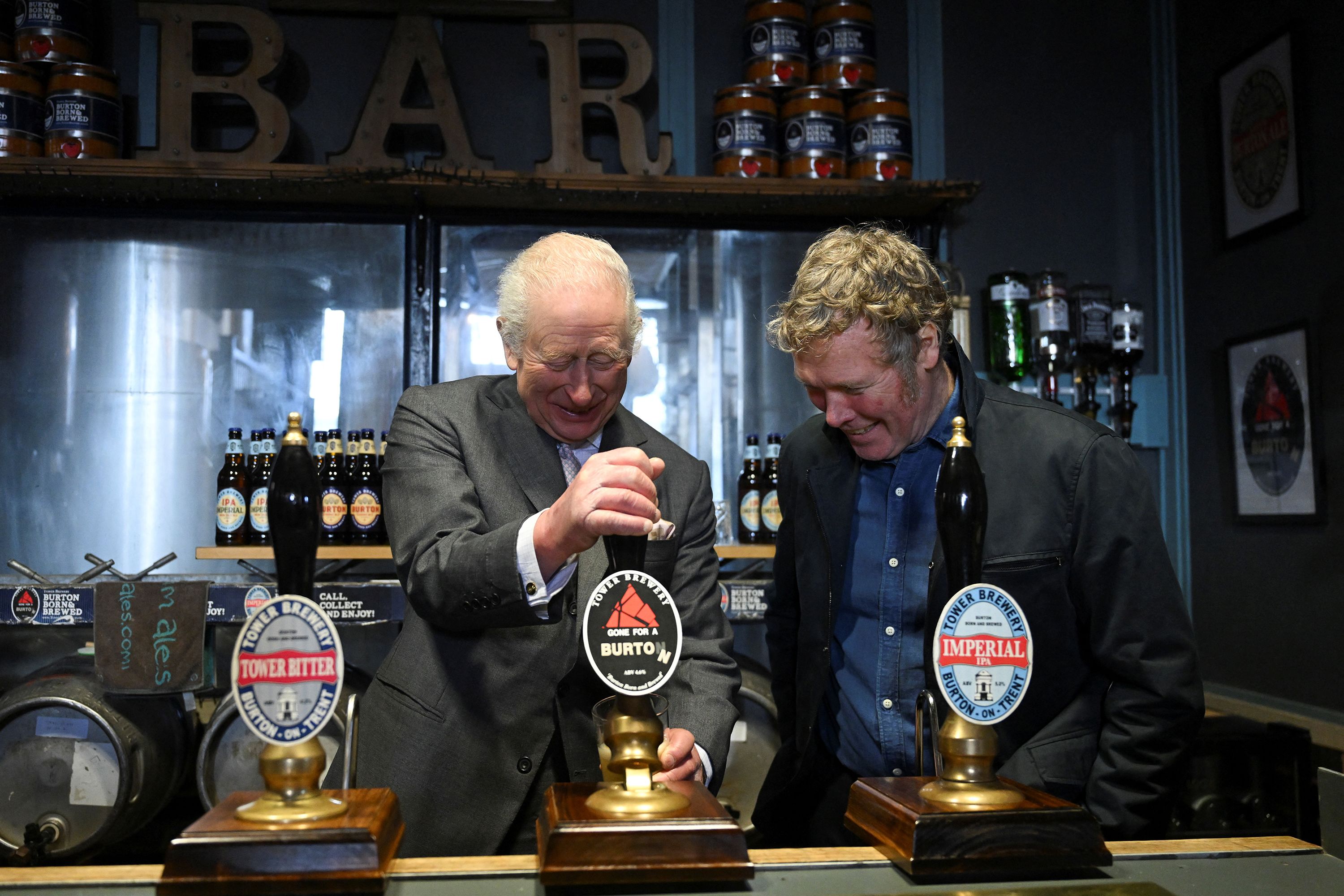 King Charles pulls a pint alongside Tower Brewery owner John Mills