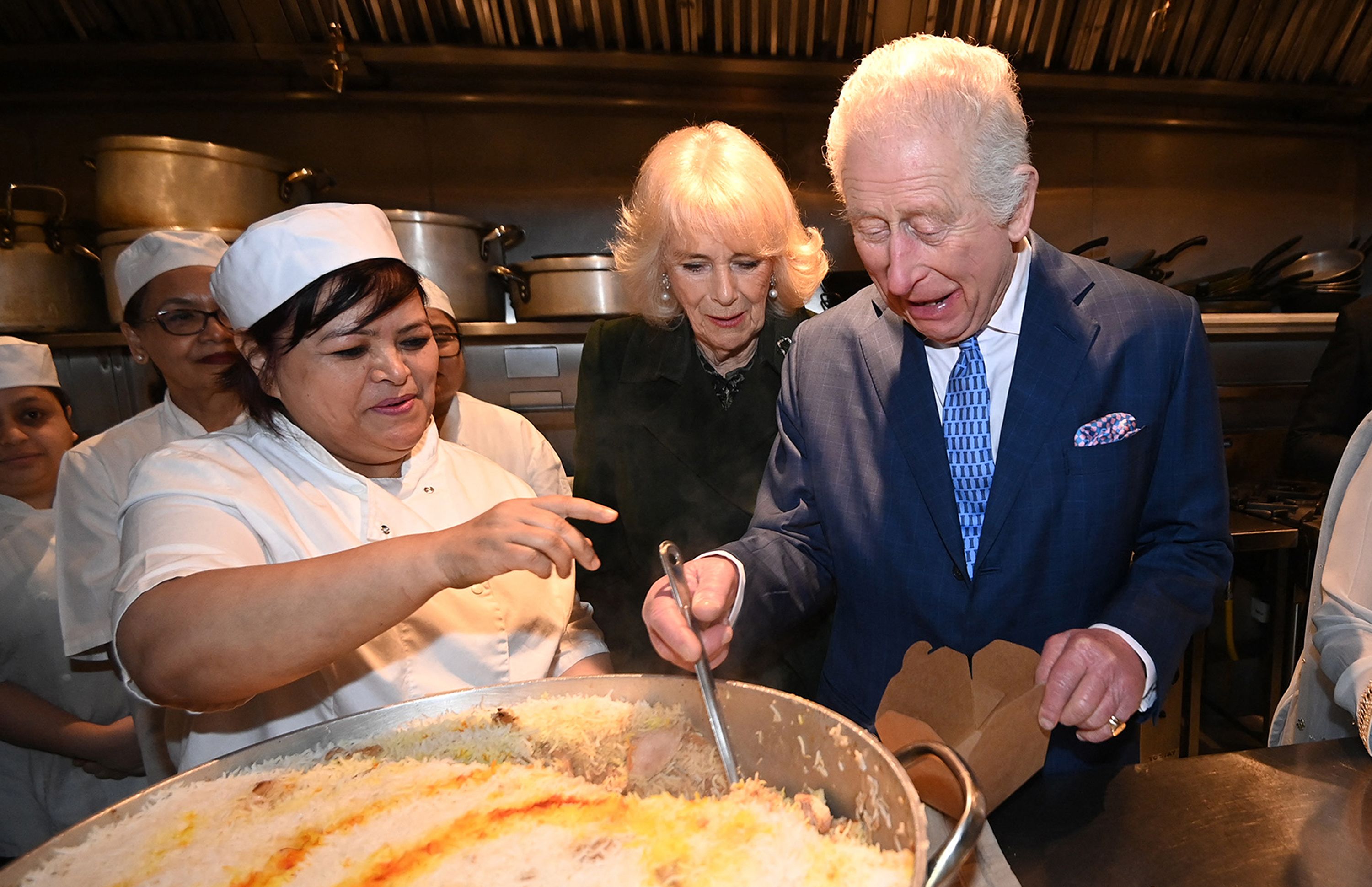 King Charles and Queen Camilla help pack donation boxes of cooked rice, with Head Chef Asha Pradhan, at Indian restaurant Darjeeling Express, during a visit ahead of Ramadan, in London 