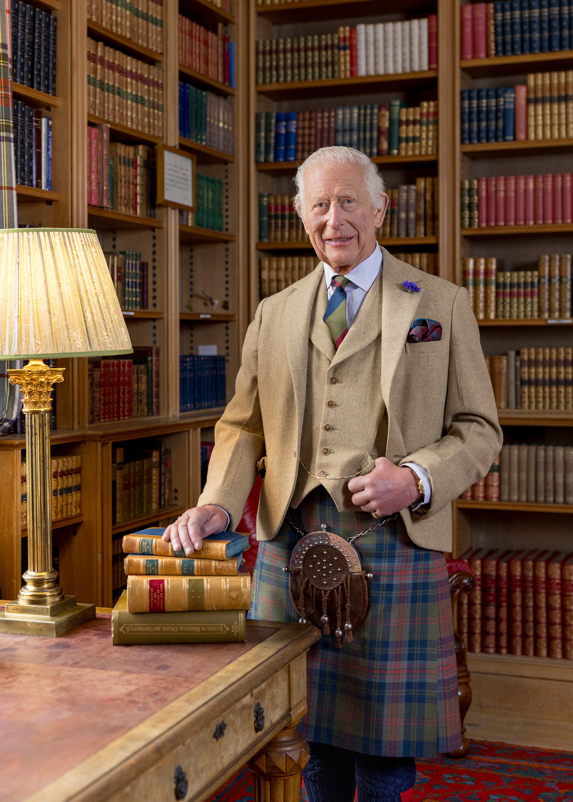 Photo of King Charles posing for a photograph in the library at Balmoral, Scotland 