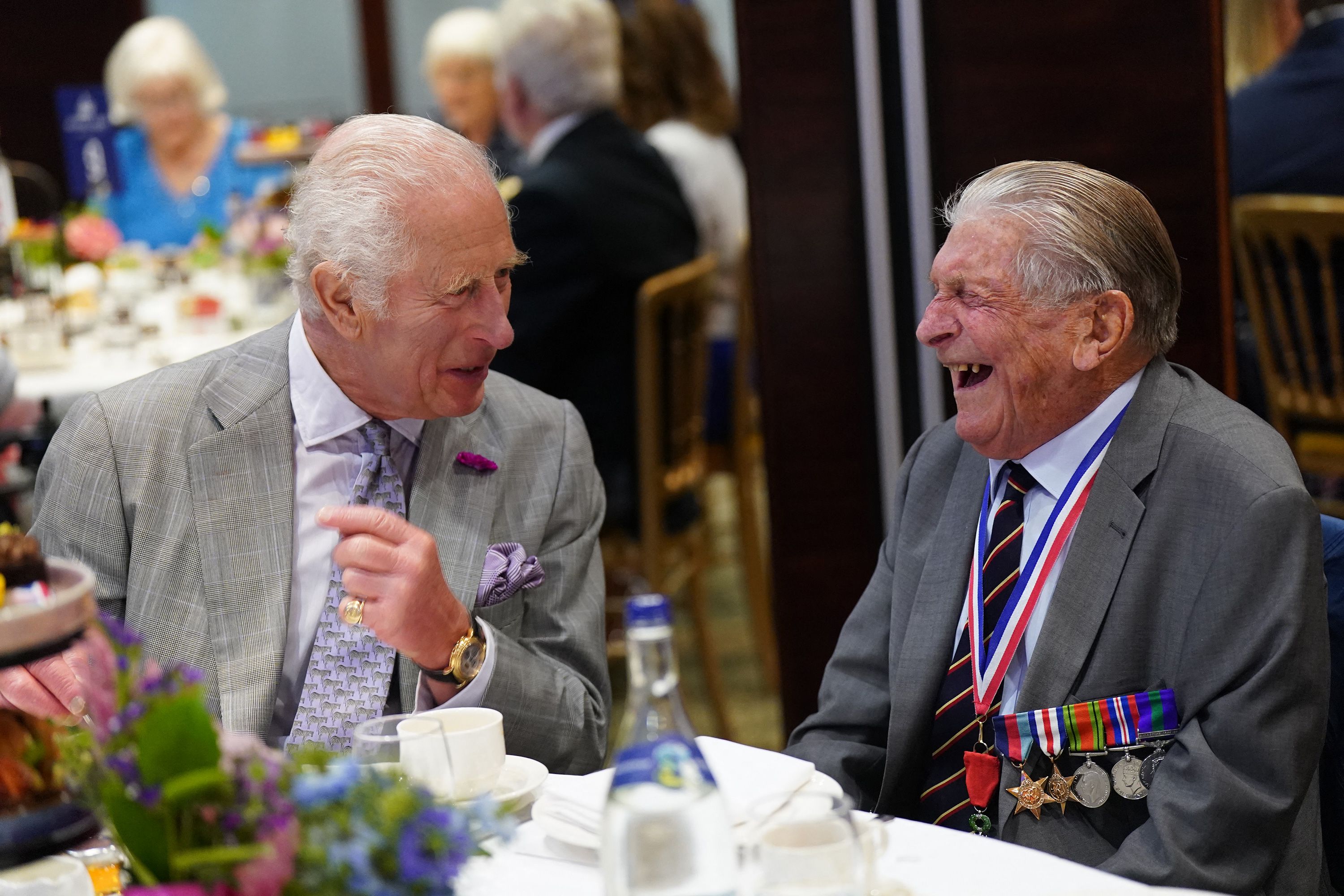 Photo of King Charles laughing with a D-Day Veteran