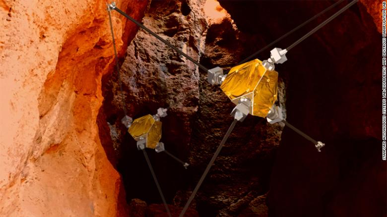 An artist's concept shows ReachBot exploring a Martian cave.