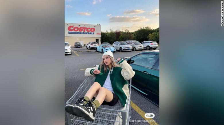 A Chinese influencer poses in the Costco parking lot in Shanghai.