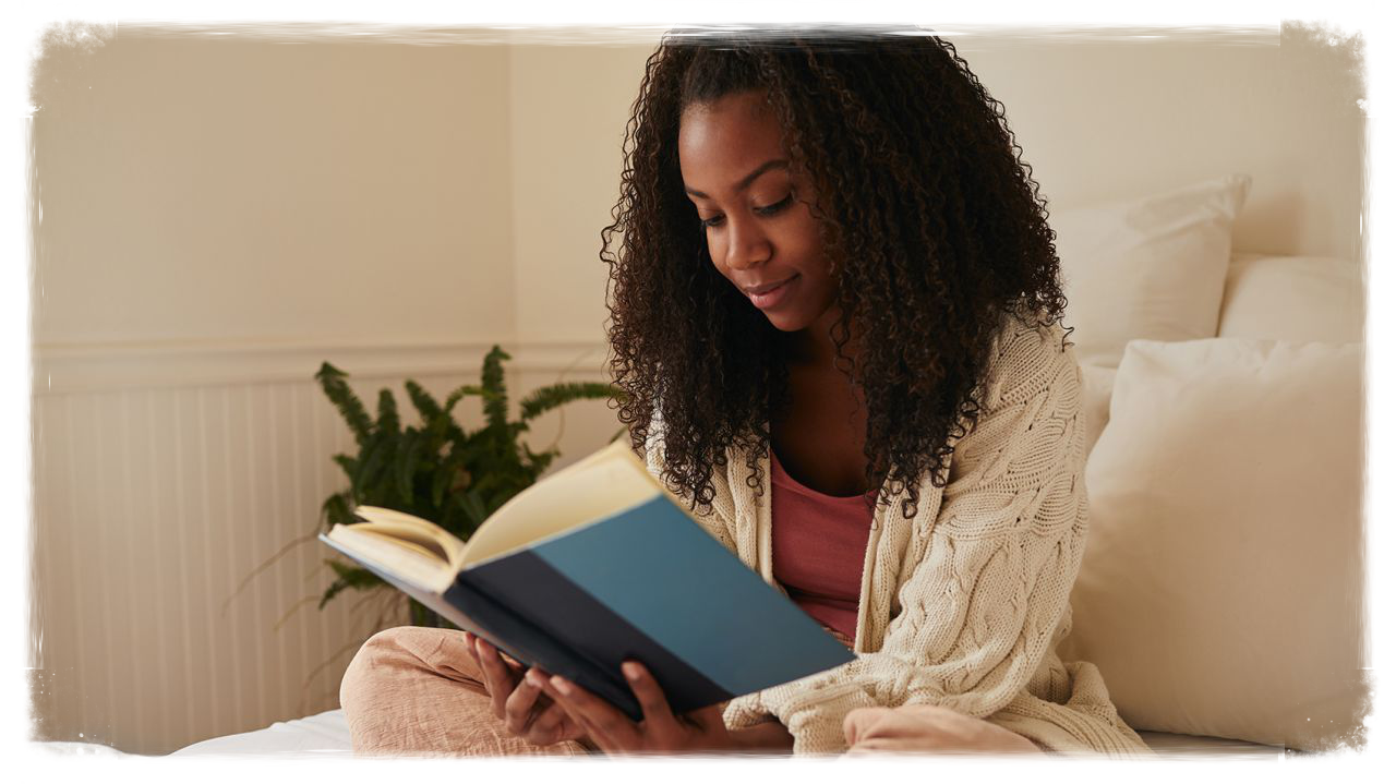 Person reading a book in bed.