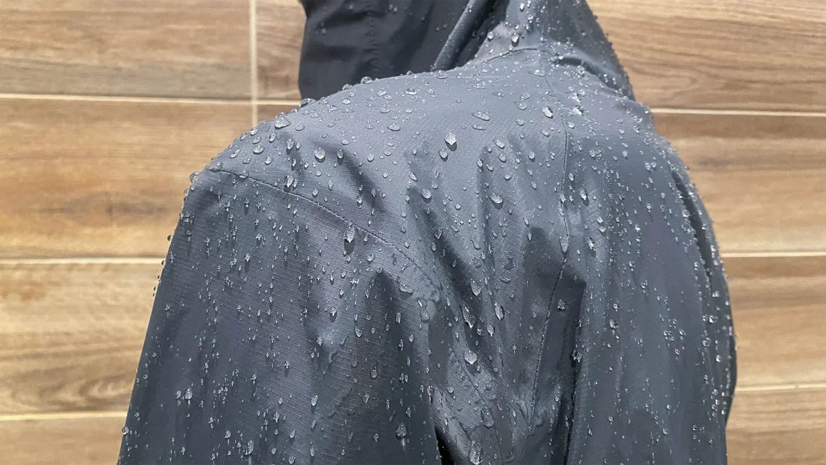 Black rain jacket covered in water droplets