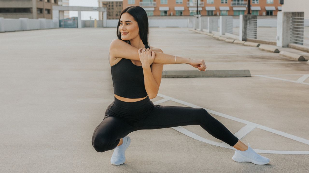 Person stretching while wearing black leggings and top