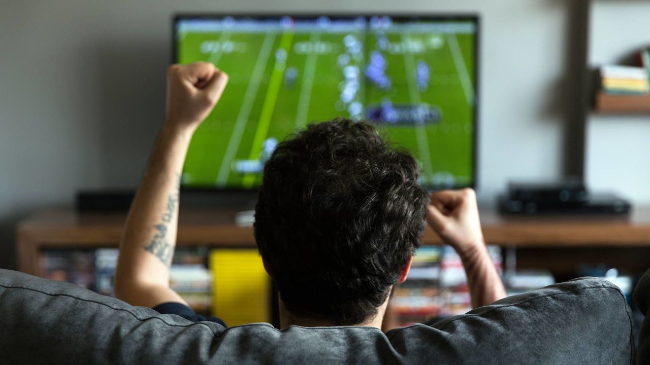 Person watching football on a TV